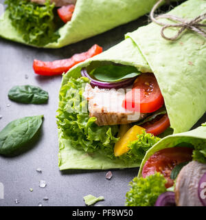 Grüne Spinat Tortilla mit Hähnchen und Gemüse. Gesunden Snack. Close Up. Stockfoto