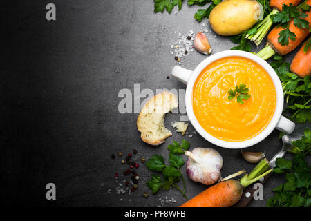 Karotten Creme - Suppe auf Schwarz. Vegetarische Gemüsesuppe. Ansicht von oben kopieren. Stockfoto