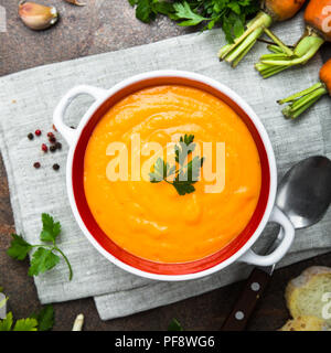 Karotten Creme - Suppe auf dunklen Tisch aus Stein. Vegetarisches Gemüse Suppe. Ansicht von oben. Platz. Stockfoto