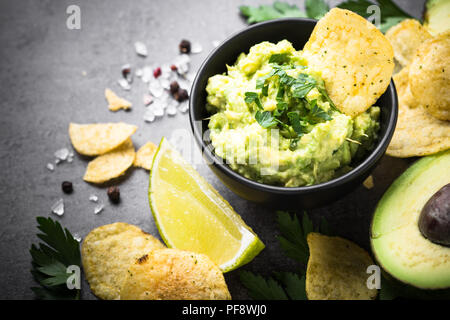 Traditionelle lateinamerikanische mexikanische Soße guacamole Chips und Zutaten auf Schwarz. Stockfoto