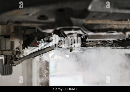 Automechaniker Inspektion und Reparatur Auto rad aufhängung Detail. Aufgehoben Auto mit Reparatur Service Station. Austausch der Hülse und Nutzen Stockfoto