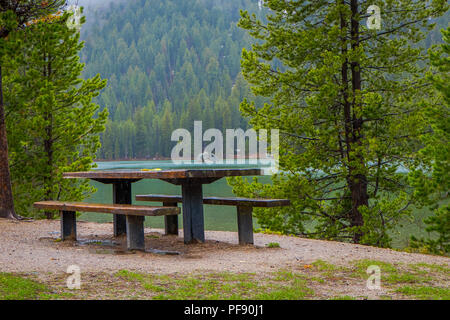 Schöne im Hinblick auf metallische und hölzernen Tisch einen Stuhl in der Seeufer mit einer wunderschönen Landschaft vom Jenny See im Grand Teton Nation Stockfoto