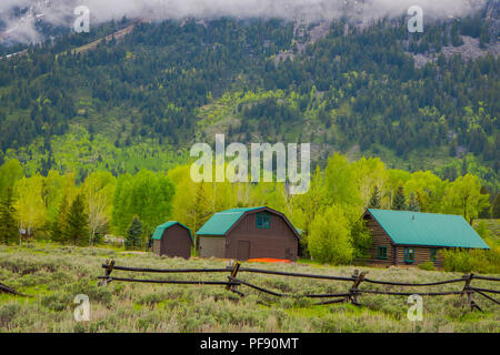 Schöne im Blick auf Häuser aus Holz braun mit grünem Dach im lamar Valley im Yellowstone National Park, Wyoming mit einem Berg hinter, Pa Stockfoto