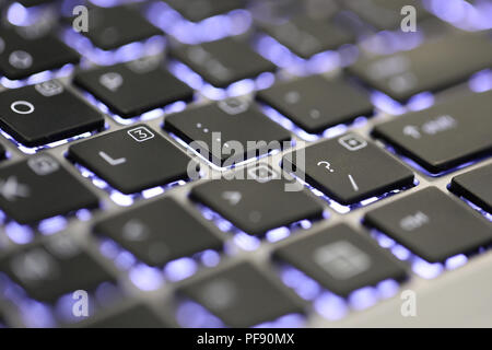 Nahaufnahme der Fragezeichen Sonderzeichen auf einer beleuchteten Tastatur auf einem Laptop oder Computer. Stockfoto