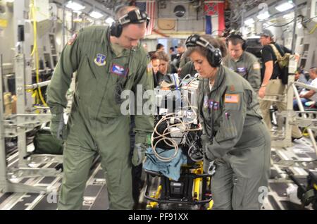 Flieger mit der Ampel an der 183rd Entlüftung Squadron, California Air National Guard, Offload einen Patienten in Galveston, Texas, 7. Juni 2018. Sie arbeiteten mit einer gemeinsamen medizinischen Teams von Joint Base San Antonio, Texas, en route medizinische Behandlung für sechs verletzte Kinder während der US Air Force humanitären Luftbrücke aeromedical evacuation Mission aus Guatemala nach der jüngsten Fuego Volcano Eruption. Stockfoto