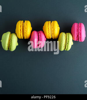 Mehrfarbige runden Kuchen mit Sahne macarons auf schwarzem Hintergrund, Kopie Raum Stockfoto