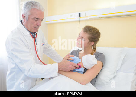 Arzt prüfen babys Herzschlag mit neuen Mutter beobachten Stockfoto