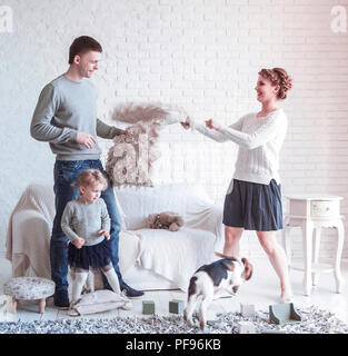 Happy Family spielen mit einem Hund in das geräumige Wohnzimmer Stockfoto