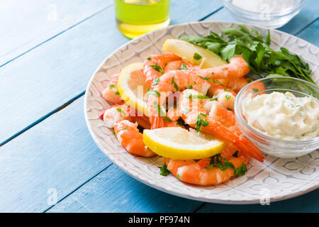 Gegrillte Garnelen, Petersilie und Zitrone auf Blau Holztisch Stockfoto