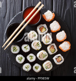 Japanisches Essen: ein Menü der Rollen mit Meeresfrüchten close-up mit Soßen auf einem Stein board. nach oben Ansicht von oben Stockfoto
