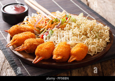 Fried Tempura Crab Claws mit ei Nudeln und Gemüse Salat close-up auf einem Teller auf dem Tisch. Horizontale Stockfoto