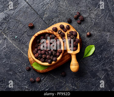 Getrocknete Weißdornfrüchte auf schwarzem Hintergrund. Blick von oben auf die Crataegi fructus. Stockfoto