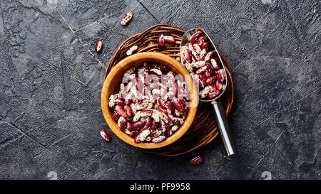 Rote Bohnen mit weißen Flecken auf schwarzem Hintergrund. Ansicht von oben. Stockfoto