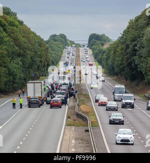 Autobahn geschlossen mit queuing Verkehr und die Leute aus ihren Autos auf der Autobahn A1, Ausfahrt 7 Richtung Süden in Hertfordshire Stockfoto
