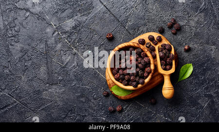 Getrocknete Weißdornfrüchte auf schwarzem Hintergrund. Blick von oben auf die Crataegi fructus. Stockfoto