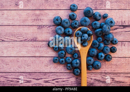 Frisch und saftig Blaubeeren in einem Löffel aus Holz auf Holz Tisch mit Copyspace. Gesunde Ernährung Konzept. Stockfoto