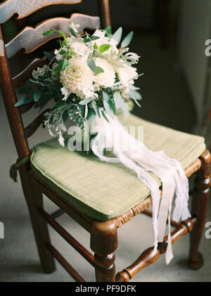 Wedding Bouquet creme weiß grün Dahlien Eukalyptus auf Stuhl mit Streams von Ribbon Stockfoto