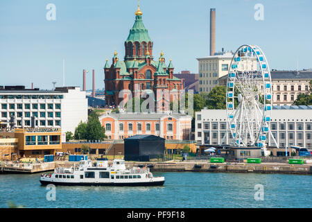 Helsinki Stadtbild, Blick auf eine Fähre Schiff segeln durch Helsinki Hafen mit der Uspenski-kathedrale und die FInnair Sky Wheel im Hintergrund, Finnland. Stockfoto
