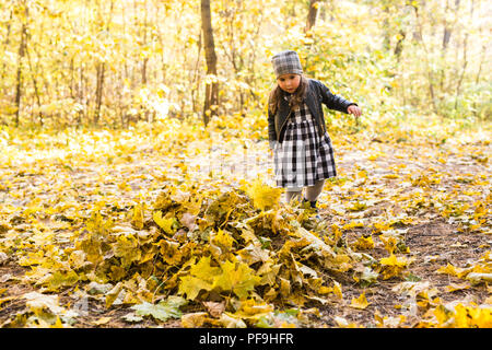 Kindheit, Herbst, Personen Konzept - Kind Mädchen spielen im Herbst Blätter Stockfoto