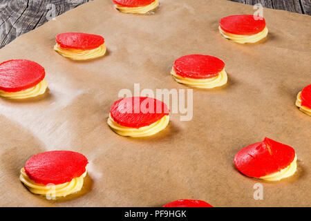 Teig mit Rote Erdbeere zum Backen kuchen Shu eclairs auf einem Pergament Papier bröckeln, klassische französische Rezept, close-up Stockfoto