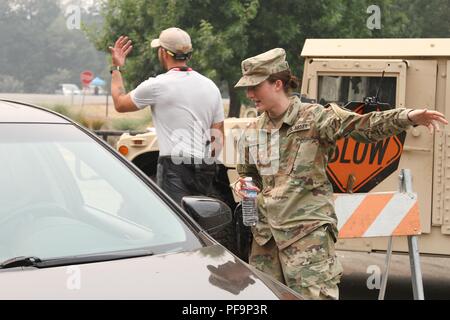 US-Armee Pfc Alaina befreit von 185 militärischen der Kalifornien Army National Guard Polizei Battalion, 49th Military Police Brigade, hilft ein Anwohner der Eingabe Shasta Hochschule 30. Juli in Redding, Kalifornien, wo Bereitschaftsdienste eingerichtet wurden, die den Opfern der Carr Feuer, 31. Juli 2018 Hilfe. Mit freundlicher Staff Sgt. Edward Siguenza / Kalifornien Nationalgarde. () Stockfoto