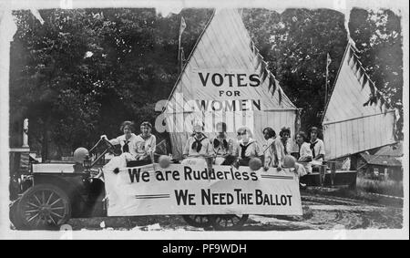 Schwarz-weiß Foto zeigt eine Gruppe von jungen weiblichen suffragists, tragen Kostüme, auf ein float dekoriert, um ein Boot zu ähneln, sitzt, das Großsegel lautet "Stimmen für Frauen, "und das Festzelt lautet "Wir sind Steuerloses - Wir müssen die Abstimmung", 1900. () Stockfoto