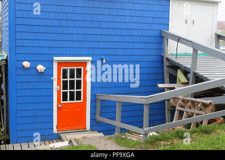 Orange Tür auf einer blauen Wand in Rose Blanche Hafen und Diamond Cove, Neufundland, Kanada Stockfoto