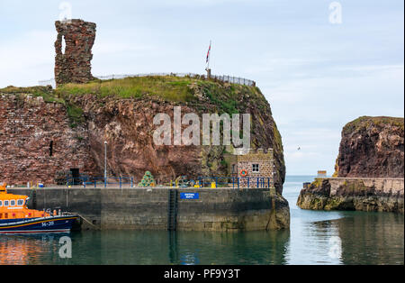 RNLI Lifeboat vertäut im Hafen, mit ruiniert Dunbar Castle, Dunbar, East Lothian, Schottland, Großbritannien Stockfoto