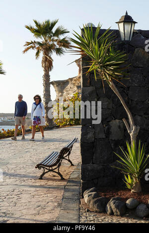 Teneriffa, Spanien - 14. März 2015. Ein Paar mittleren Alters spaziergang an der Uferpromenade an der Costa Adeje, Teneriffa, Kanarische Inseln. Stockfoto