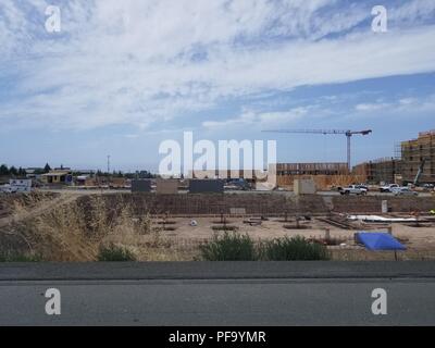 Kräne auf einer großen Baustelle in der Nähe der 680 Freeway am Rande des Silicon Valley, Fremont, Kalifornien, 30. Mai 2018. () Stockfoto