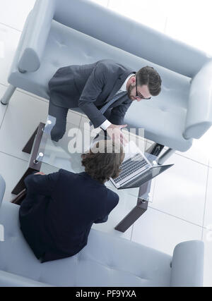 Zwei Geschäftsleute über Aufgaben im Büro sitzen. Stockfoto