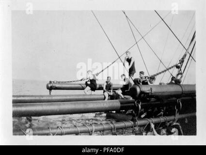 Schwarz-weiß Foto zeigt eine Gruppe von Männern, das Tragen von Badekleidung, Sitzen und Stehen auf der Takelage eines Schiffes, das Navigieren durch den Panamakanal, mit einem anderen Mann in einer großen Leinwand Pool von Wasser nach unten, 1915. () Stockfoto