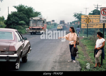 Managua, Nicaragua, Wahlen, Juni 1986; zwei junge Frauen trampen aus Managua auf dem Weg nach Masaya. Stockfoto