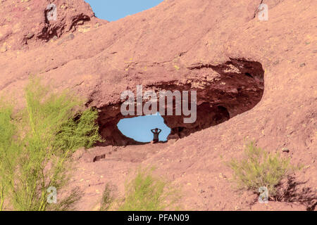 Junge Mädchen in einem Loch in einem Berg bei Papago Park, Tempe, Arizona, USA sitzen Stockfoto