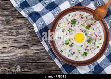 Chciken, grünen und Gemüse kalte No-Cook Suppe mit griechischer Joghurt in Ton Schüssel auf dem Tisch Serviette mit Holzlöffel, Ansicht von oben Stockfoto