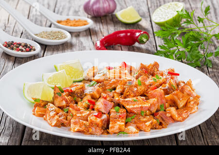 Chinesische geschmorte Schweineohren mit Gewürzen, Chili, Stücke von Kalk, bestreut mit Petersilie auf weißen platter auf die natürlichen Holz- alte Bretter, Nahaufnahme, vi. Stockfoto