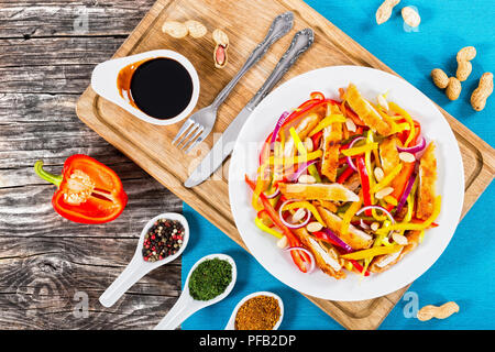 Mango, Brot panierte Hähnchenfleisch, Erdnüsse, Paprika, rote Zwiebel Salat auf einem weissen Teller,, Balsamico Dressing auf alten Karten, close-up Stockfoto