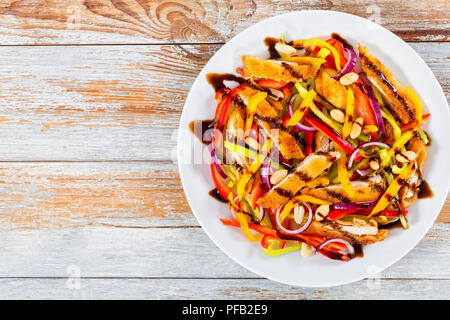 Mango, Brot panierte Hähnchenfleisch, Erdnüsse, Paprika, rote Zwiebel Salat auf Teller, Weiß auf Weiß die Farbe blättert von den Boards, Ansicht von oben Stockfoto