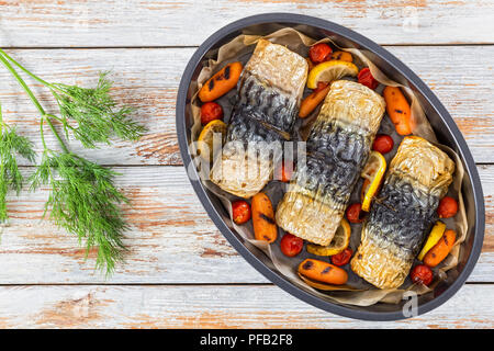 Brötchen - bis Filet Makrelen mit gegrillten Karotten, Kirschtomaten und Zitrone in Auflaufform, auf weissem abblätternde Farbe Tabelle, Ansicht von oben Stockfoto