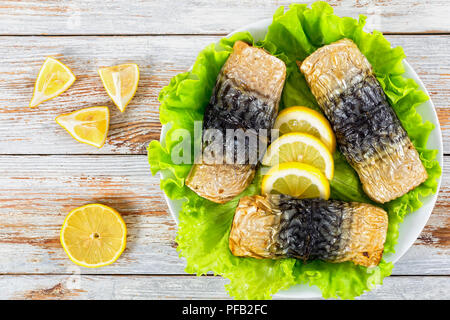 Brötchen - bis Filet Makrelen mit gegrillten Karotten, Kirschtomaten und Zitrone in Auflaufform, auf weissem abblätternde Farbe Tabelle, Ansicht von oben Stockfoto