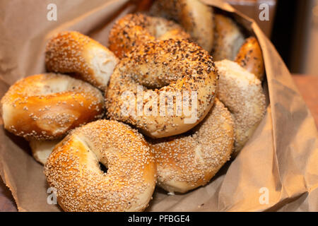 Auswahl an verschiedenen authentischen New York Style Bagels mit Samen in eine braune Papiertüte. Stockfoto