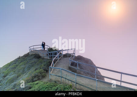 Romantisches Paar umarmen Nebel Sonnenuntergang Muir Beach überblicken. Stockfoto