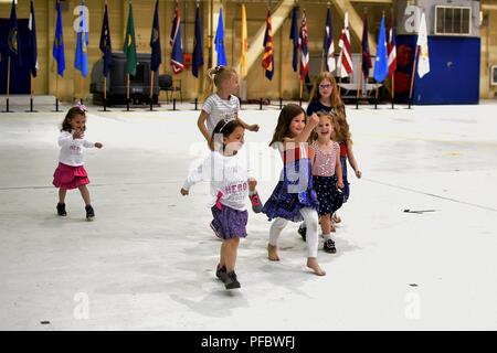 Kinder Praxis marschieren zu Musik aus dem 9. Army Band beim Warten auf die Wiedervereinigung mit ihren Soldaten. Familie und Freunde von fast 400 Fallschirmjäger ab der 4 Infantry Brigade Combat Team (Airborne), 25 Infanterie Division sammelte 2 Joint Base Elmendorf-Richardson's Hangar 1 ihre Soldaten nach Hause von einer 9-monatigen Einsatz in Afghanistan zur Unterstützung der Operation, die die Freiheit des Sentinel willkommen. Stockfoto