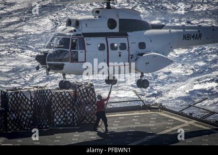 5. Flotte BEREICH VON OPERATIONEN (Juni 3, 2018) ein Matrose auf dem Trockenen Cargo und Munition Ship USNS Amelia Earhart (T-AKE 6) Paletten zu einer SA-330 J Puma Hubschrauber während einer vertikalen Auffüllung am Meer verbindet, 3. Juni 2018. Iwo Jima in Mayport, Fla. homeported, ist auf die Bereitstellung zu den USA 5 Flotte Bereich für Maßnahmen zur Erhöhung der Sicherheit des Seeverkehrs Operationen Verbündeten und Partnern zu beruhigen, und der Freiheit der Schiffahrt und des freien Handels in der Region erhalten. Stockfoto