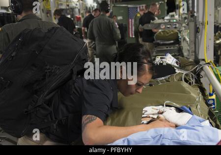 Us-Armee Kapitän Argelia Felix-Camacho, eingetragene Krankenschwester, San Antonio militärischen Medical Center brennen Team, Konsolen ein Patient während einer Luftbrücke aeromedical evacuation Mission von Guatemala bis Galveston, Texas, USA, 6. Juni 2018. Ein US Air Force C-17 Globemaster III von 172Nd Airlift Wing der Mississippi Air National Guard transportiert sechs verletzte Kinder und deren Erziehungsberechtigten in Galveston, Texas, für ärztliche Behandlung an Shriners Hospital für Kinder. Eine gemeinsame medizinische Team von der 183Rd der Mississippi Air National Guard Entlüftung Squadron und Joint Base San Antonio, Texas, sofern en route mich Stockfoto