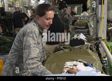 Us-Luftwaffe Kapitän (Dr.) Hannah Gale, Kinderarzt, San Antonio militärischen Medical Center brennen Team, Konsolen ein Patient während einer Luftbrücke aeromedical evacuation Mission von Guatemala bis Galveston, Texas, USA, 6. Juni 2018. Ein US Air Force C-17 Globemaster III von 172Nd Airlift Wing der Mississippi Air National Guard transportiert sechs verletzte Kinder und deren Erziehungsberechtigten in Galveston, Texas, für ärztliche Behandlung an Shriners Hospital für Kinder. Eine gemeinsame medizinische Team von der 183Rd der Mississippi Air National Guard Entlüftung Squadron und Joint Base San Antonio, Texas, sofern en route Medic Stockfoto