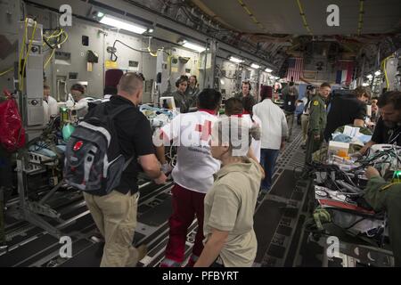 Us-Armee Maj. Julie Rizzo, Mitte, Brennen, Chirurg und Team führen von San Antonio militärischen Medical Center in Joint Base San Antonio, Texas, leitet das Personal beim Laden der Patienten auf ein Air Force C-17 Globemaster III während einer humanitären Mission, 6. Juni 2018. Die C-17 Globemaser III aircrew von 172Nd Airlift Wing der Mississippi Air National Guard, transportiert sechs Kinder aus Guatemala, die ärztliche Behandlung in Galveston, Texas zu erhalten, für Verbrennungen und anderen Verletzungen während der jüngsten Fuego Volcano Eruption, die am 3. Juni begann. Stockfoto