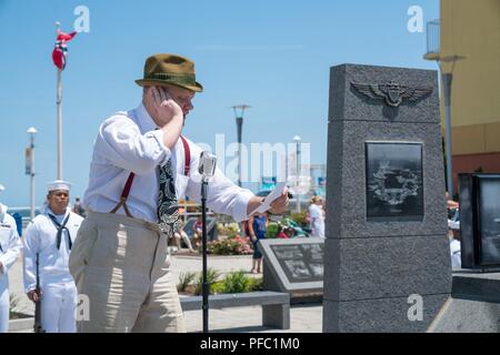 VIRGINIA Beach, Va (Juni 07, 2018) - Ryan Clemens, ein Schauspieler von Lernkurve Unterhaltung, schildert ein WWII ära Radiosprecher auf der 76. Jahrestag der Schlacht um Midway Gedenkfeier in Virginia Beach. Die Zeremonie, von Commander, Naval Air Force, Atlantic, inklusive original Re-inszenierungen, ein WWII ära Flugzeug Überführung und Reden von der hinteren Adm. Kenneth R. Whitesell, Commander, Carrier Strike Group 4 und Virginia Beach Bürgermeister Louis Jones. (US Navy Stockfoto