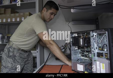 Us Air Force Staff Sgt. Johnathan Rico Arce, einem Client Systeme Techniker mit dem 823 RED HORSE Squadron, überträgt Desktop Workstation Daten auf einen neuen Laptop Festplatte, 30. Mai 2018, am Hurlburt Field, Fla. Alle 823 RHS Flieger neue Laptops neben einen Übergang zu einem neuen Betriebssystem, das die Vertraulichkeit und Integrität bei der Kontingenz und spezielle Operationen weltweit fördert. Stockfoto