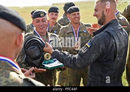 Soldaten mit 1 Tank Company, 14. mechanisierte Brigade aus der Ukraine begabt ist ein Tanker Helm zu den Soldaten der 3. Panzer Bataillon aus Deutschland. Die starke Europa Tank Herausforderung ist eine jährliche Veranstaltung, die von der US-Army in Europa und der Deutschen Armee gehostet und ist für die teilnehmenden Nationen zu einem dynamischen, produktiven und Spaß Umfeld, in dem die militärische Partnerschaften zu fördern, form Soldat - Beziehungen auf, und teilen Sie Taktiken, Techniken und Verfahren. Stockfoto